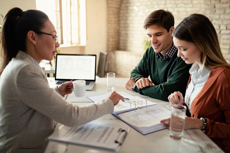 smiling-couple-insurance-agent-going-through-real-estate-plans-meeting-office-focus-is-man_637285-2808.jpg